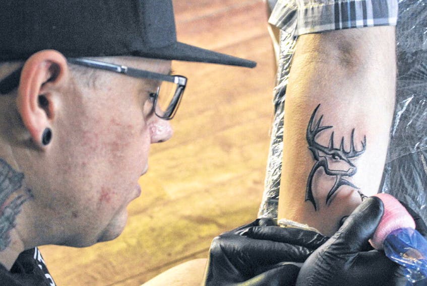 Jason Mahar, owner of Everlasting Ink in Kentville, works on a tattoo for client Dennis Arenburg on Wednesday. The province’s Safe Body Art Act was proclaimed on Tuesday, with its regulations to take effect next February.
IAN FAIRCLOUGH • THE CHRONICLE HERALD