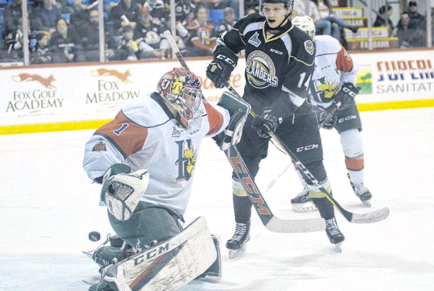 Halifax Mooseheads goalie Alexis Gravel makes a blocker save as Charlottetown Islanders centre Nikita Alexandrov looks for a rebound during first-period QMJHL playoff action on Wednesday in P.E.I.