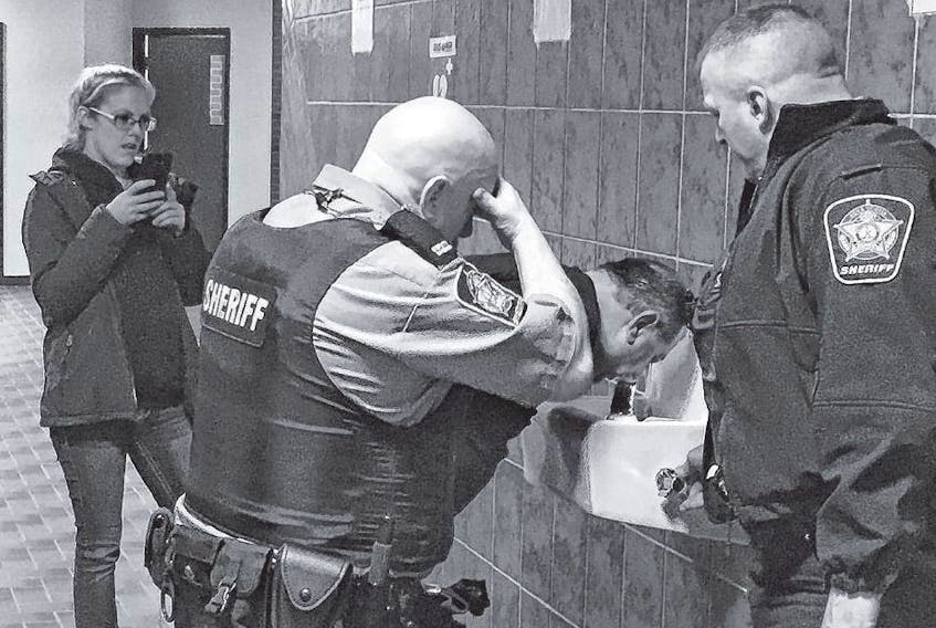 Deputy sheriffs help Darrin Rouse flush his eyes after he was pepper-sprayed during a scuffle with deputies at Nova Scotia Supreme Court in Kentville on Tuesday morning. IAN FAIRCLOUGH • THE CHRONICLE HERALD