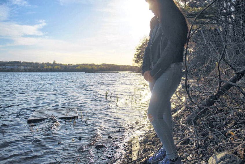 Emily Brown stand along First Lake in Lower Sackville on Wednesday night. RYAN TAPLIN • THE CHRONICLE HERALD