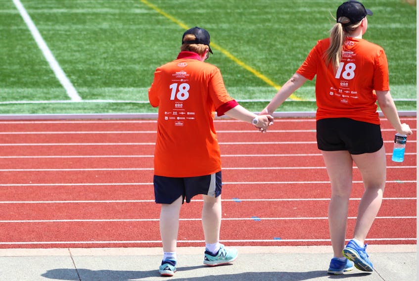 Special Olympian, Tracy MacKinnon, left, and Hannah MacDonald walked together toward their next game at the CBU soccer pitch.