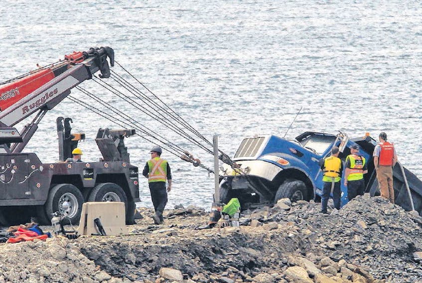Salvage workers remove a tandem truck from a dumping area at Fairview Cove in Halifax on Wednesday. On Monday, a man’s body was found floating near the MacKay Bridge. The Nova Scotia Department of Labour is investigating.
TIM KROCHAK