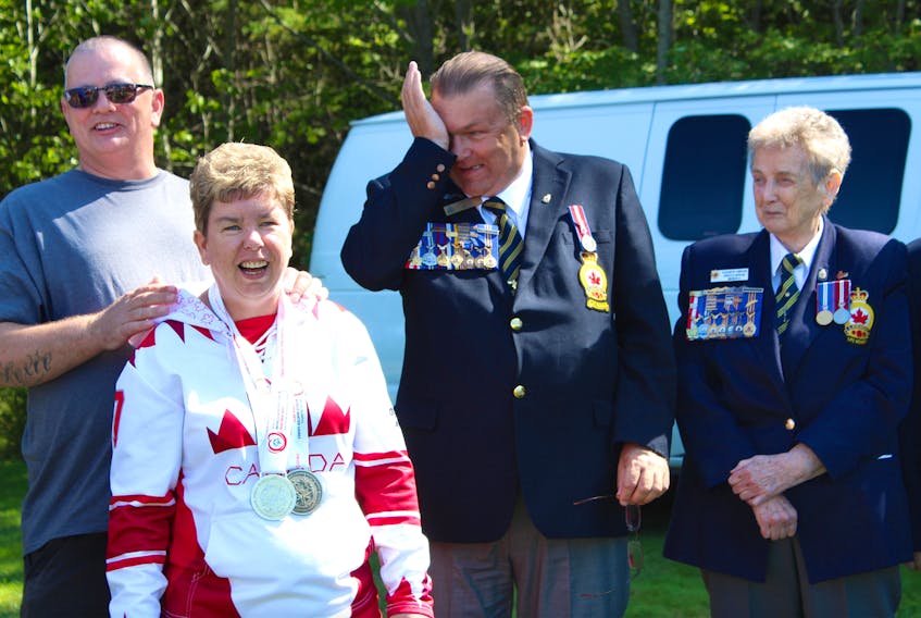 Decorated speed-skater and Special Olympian Aimee Gordon receives a pat on the back from her younger brother, Sandy, and praise from members of Royal Canadian Legion Branch 008 at a ceremony adding Gordon’s name to the welcome sign in Sydney Mines.