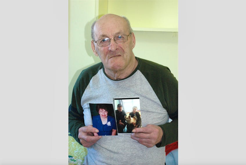 Wallace Cunard, 76, holds two pictures of his wife, Rita, 71. The two have been married for 54 years but since last year, they’ve been unable to live together.