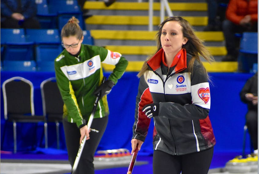 Ontario skip Rachel Homan slides along the ice past Krista McCarville of team Northern Ontario during Draw 20 action Saturday at Centre 200 in Sydney, N.S.