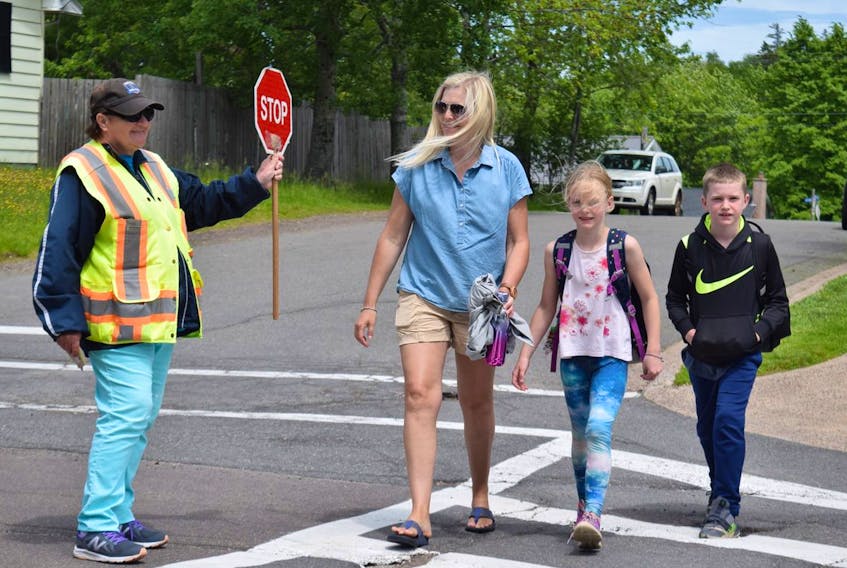For 19 years, Janet Melanson has been a constant for schoolchildren crossing Truro’s roads. From left, Janet Melanson, Heidi Nicholson and her children, Ila and Ben, who attend Truro Elementary School.