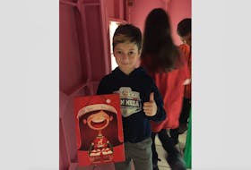 Lucas Kennedy was one of many youth to deliver a gift inside the Gingerbread House during the opening ceremony on Nov 13. CONTRIBUTED