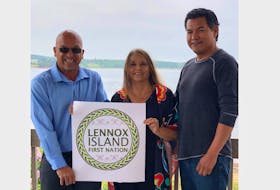 Councillors Richard Guimond, left, and Wendall Labobe and Chief Darlene Bernard hold the newly designed logo for Lennox Island First Nation.