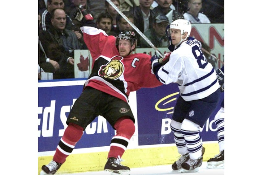 Former rivals Daniel Alfredsson, left, and Alexander Mogilny, battle in the playoffs while with Ottawa and Toronto, respectively. - Post Media