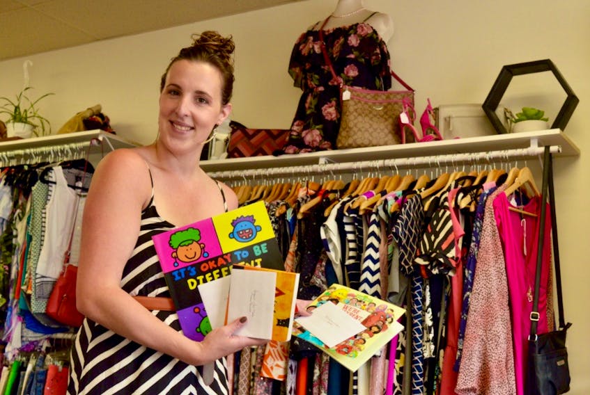 Shawna Perry, owner of Little Black Dress in Summerside, shows some of the books she was able to buy with the proceeds from a recent sidewalk sale. The books have been donated to daycares across the province.