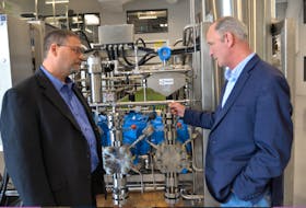 Jonathan Gluckman, left, of Sixth Wave Innovations Inc., and David Campbell of Advanced Extraction Systems in Charlottetown discuss cannabis extraction on Wednesday after the two companies entered into a partnership.