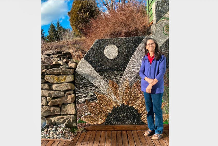 Nancy Turniawan stands beside the pebble mural at her home in Harbour Centre called Finding Joy. The artwork expresses the amazing possibility of the seeds of life.