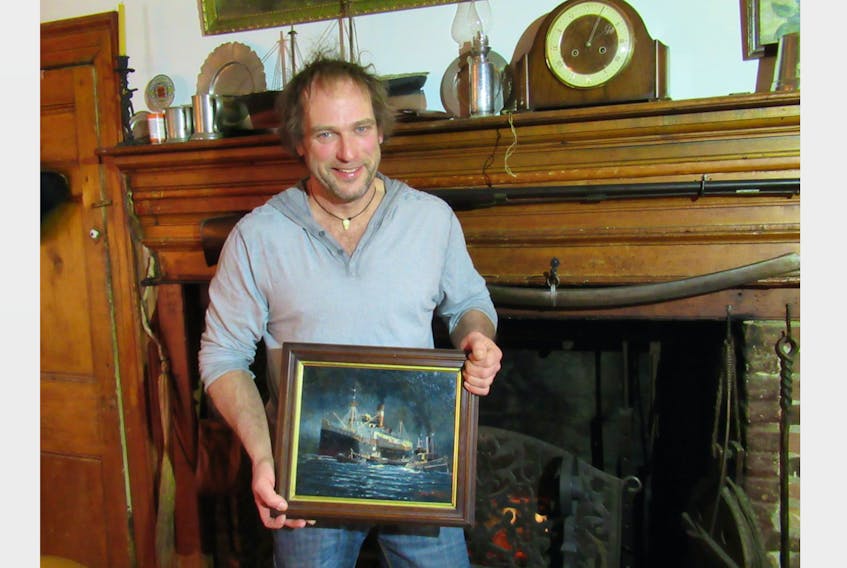 Celebrated marine artist Yves Bérubé displays one of his smaller oil paintings in front of the original fireplace in his circa 1771 Rose Bay home. Peter Simpson Photo