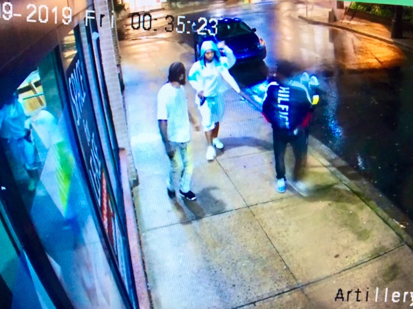 An image from surveillance video shows Demarqus Shane Beals, left, Devonte Denzel McNeil and Jayree Vontaze Downey walking along Artillery Place in Halifax shortly after a shooting on nearby Dresden Row on Aug. 9, 2019.  McNeil is holding a pistol in his right hand. - Contributed
