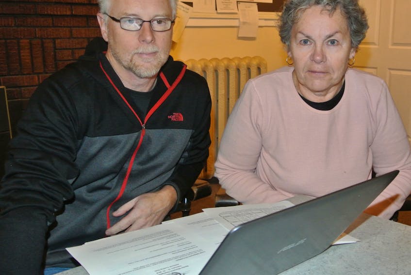 Nova Scotia Senior Curling Championships organizing committee chairman Peter Rushton and Nova Scotia Curling Association liaison Chris Manuge look over plans for the championships at the Amherst Curling Club from Feb. 15 to 19.