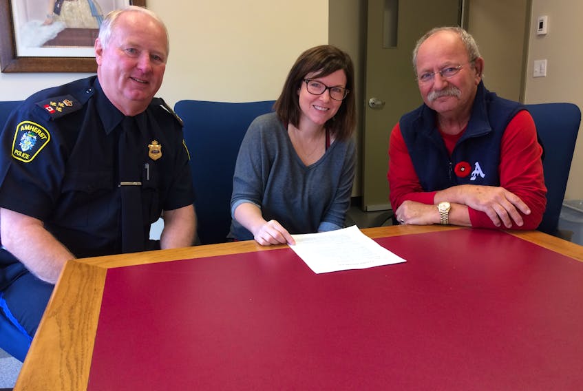 Amherst Police Chief Ian Naylor, L.A. Animal Shelter president Terri McCormick and Amherst Mayor Dr. David Kogon look over a copy of the town’s animal control bylaw. The bylaw, set by the town, sets out the fines and fees for stray dogs within Amherst.