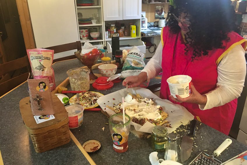 Moyra Boone prepares a pan of nachos during an episode of The Singing Chef. The Sackville, N.B. woman offers three shows a week to her followers on social media.
