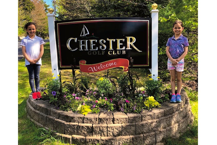 The Snook Twins, Mila and Freya, pose at the sign leading the way into the Chester Golf Club in Nova Scotia, where they were competing in the US Kids Golf World Championship qualifier on June 8. Mila won the event, carding a 47 to earn a trip to North Carolina Aug. 1-3. — Submitted photo