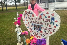 Judy Brown of Southampton stands beside a large sign she erected in front of her home. She said it’s a way for her community to send their thoughts to the victims of the Portapique shooting and their families. Darrell Cole – Amherst News