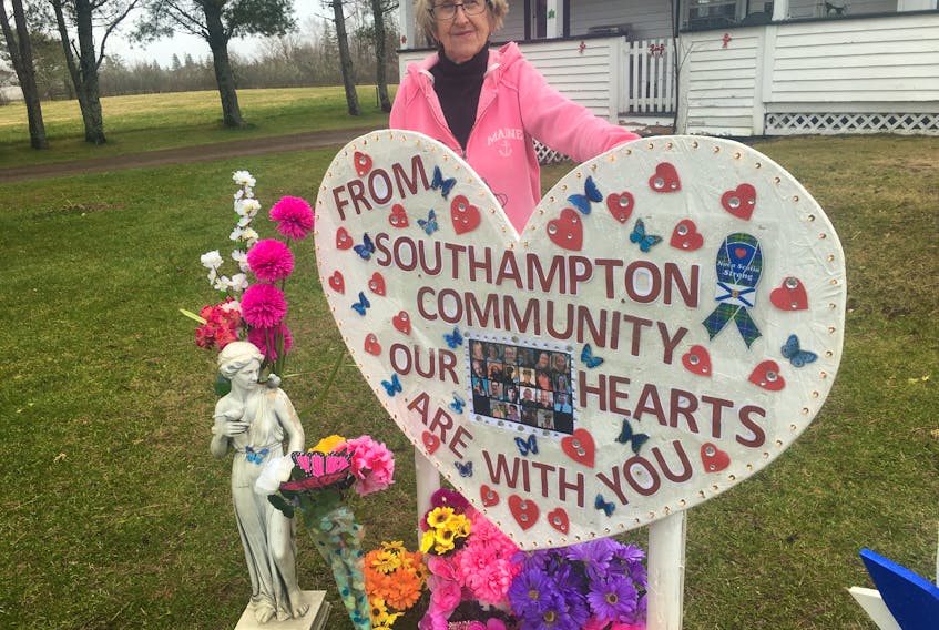 Judy Brown of Southampton stands beside a large sign she erected in front of her home. She said it’s a way for her community to send their thoughts to the victims of the Portapique shooting and their families. Darrell Cole – Amherst News