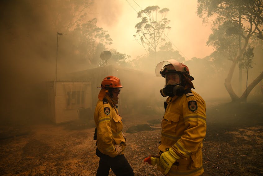 Fire crews work to protect a property in Kulnura as the Three Mile fire approaches Mangrove Mountain, Australia, on Dec. 6, 2019. - Reuters