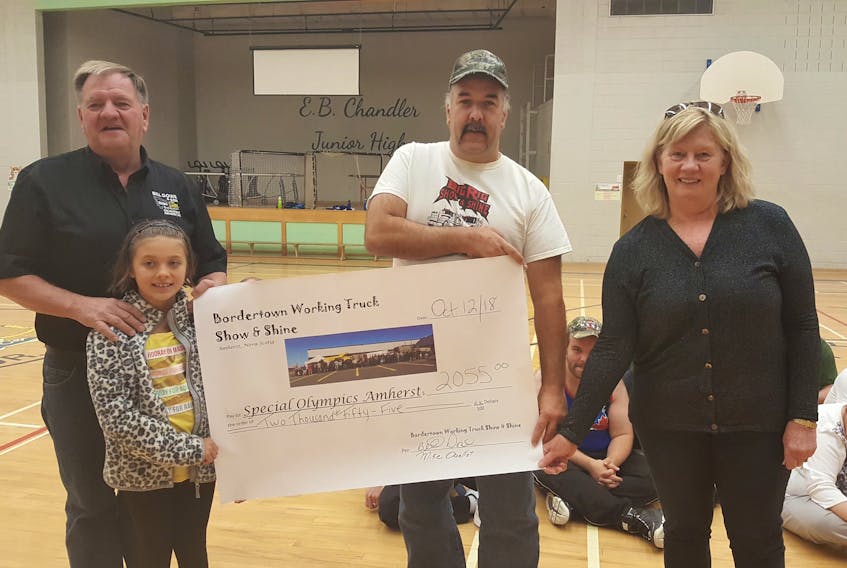 Bill Dowe (left) and Mike Ouellet (right) of the Bordertown Working Truck Show, held in September in Amherst, and Leah McLean of Bill Dowe Excavating present a cheque for $2,055 to Martha Saunders of Amherst Area Special Olympics.