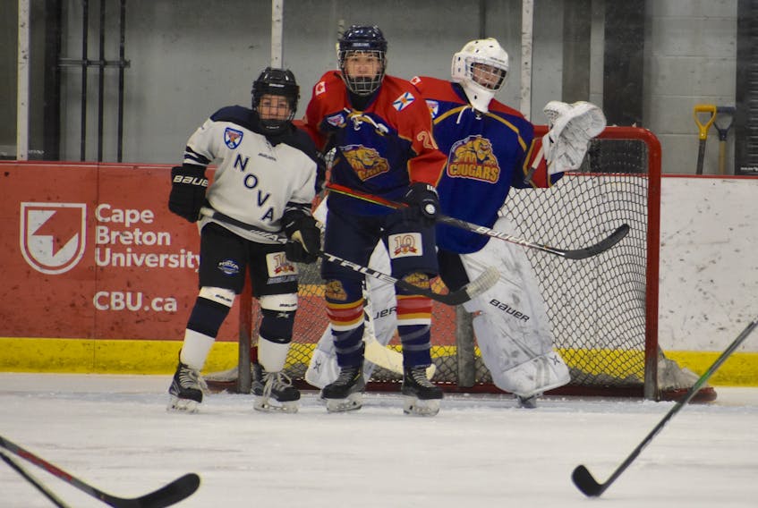 Three's a crowd as Joneljim Cougars goalie Andrew Burke, right, leans past defenceman James Jobes and Novas forward Daniel Chiasson during Nova Scotia Major Bantam Hockey League action at the Membertou Sport and Wellness Centre on Sunday afternoon. Novas won 6-1.
