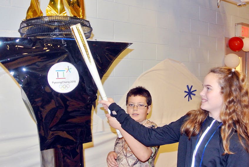 Zachery Fullerton and Lauren Beed ‘light’ the cauldron to officially begin the Winter Games celebration at Spring Street Academy in Amherst.