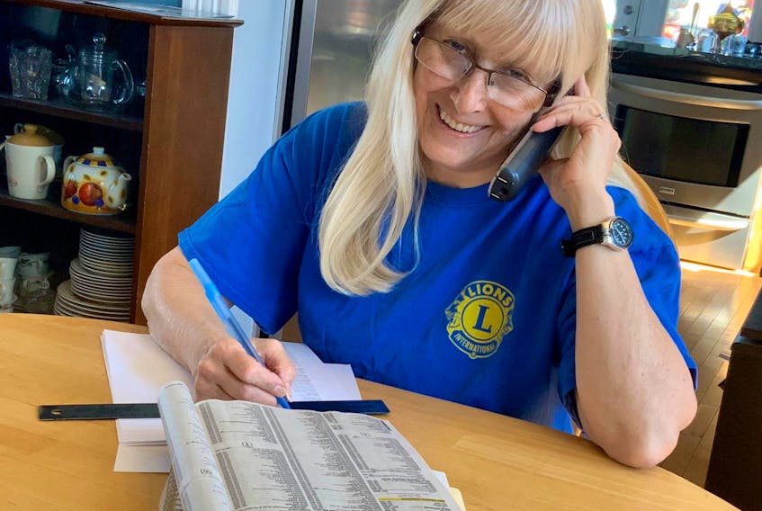 Springhill Lions Club acting King Lion and vice president Wendy Fraser goes through the phone book to gather phone numbers for the community care call program. It’s one of a couple of things the club is doing to help community members during the COVID-19 crisis.