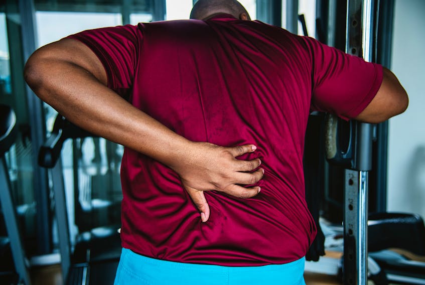 Stock photo  -  man with back pain at the gym