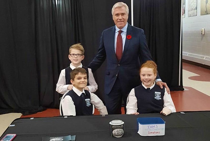 Mark Janes (back left) greets Premier Dwight Ball (back right) with Jack Richardson (front left) and Rebecca Janes (front right) during the Municipalities of Newfoundland and Labrador Banquet. The students organized a coat check to raise money for their upcoming Intermediate Skills Canada Challenge.