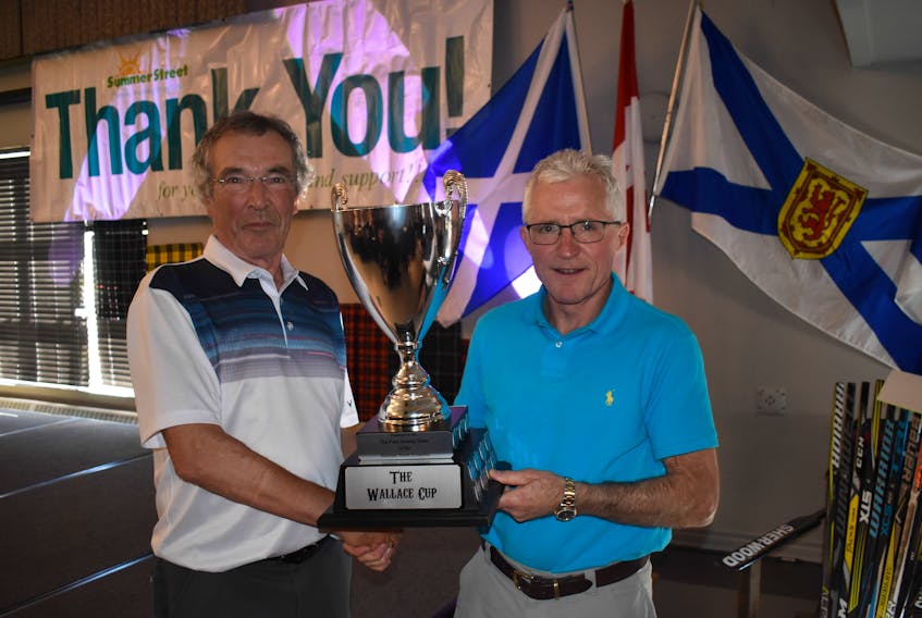 David Wallace (left) presents Howie Anderson of CIBC Wood Gundy the Wallace Trophy for the most funds raised at this year’s Summer Street Scramble.