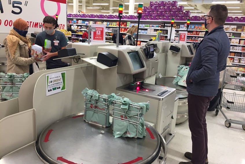 Customers work the self-checkouts at the Atlantic Superstore on Joseph Howe Drive in Halifax on Wednesday, Oct. 28. The plastic bags available for customers will be replaced when the provincial single-use plastic bag ban is imposed on Friday.