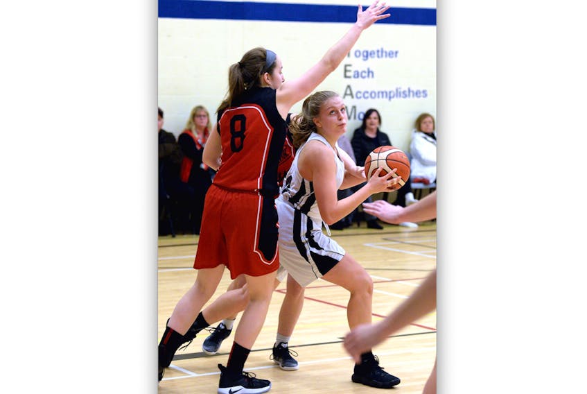 Carly Stevenson of the Holy Heart Highlanders looks for room to make a play on Rebecca Tobin of the Waterford Valley Warriors during round-robin play in the 10th annual Clarence Sutton Memorial basketball tournament Saturday at St. Kevin’s High School.