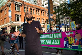 Syed Hussan, a coordinator for the Migrant Workers Alliance for Change, is pictured at an Aug. 23 Toronto rally calling for full and permanent immigration status for all people in Canada.