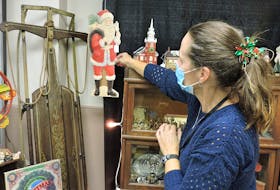 Jackie Pitt arranges her display of holiday-themed antiques at this year's Christmas at the Forum gift market. To allow for smaller crowds and a wide array of sellers, the event is taking place over several weekends up until Dec. 18 to 20.