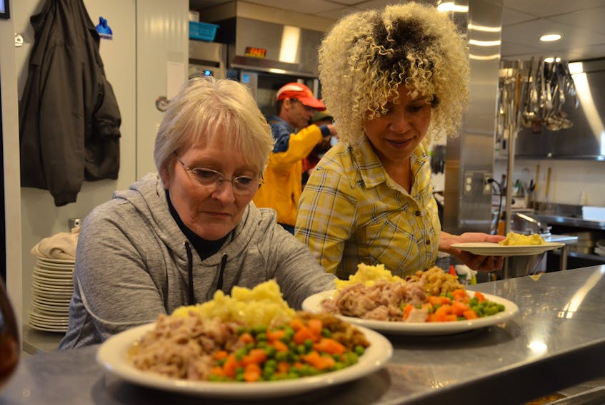 Dorcas MacKenzie, left, and Tanya Colbo prepare plates loaded with vegetables, turkey and all the trimmings at Souls Harbour Rescue Mission in Halifax on Friday.