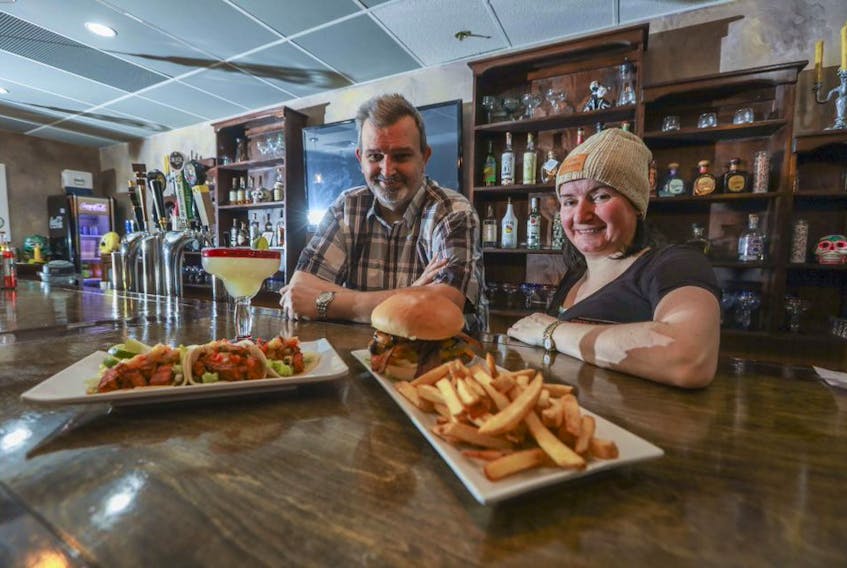 Earl and Carol-Ann Abbott are celebrating 10 years of Cheachie's at their location at 102 Chain Lake Dr. in Bayers Lake park. The authentic Mexican restaurant has been a labour of love for the couple. In front of them is a "Big Earl" hamburger with bacon and onion rings, a "Pollo de Ranchero" and lime margarita. ERIC WYNNE/Chronicle Herald