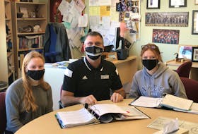 Kevin Veniot, principal of Northeast Kings Education Centre, sits with students Leah Bent and Emily Rutt at the school on March 12, 2021. Veniot said the school has adapted well to the turbulent pandemic year thanks to lots of prepration and co-operation among staff on technological changes.