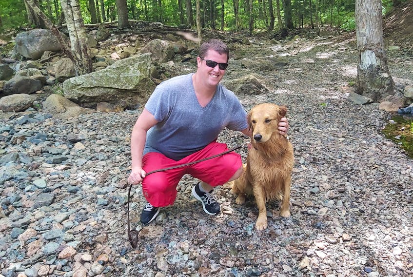 Tyler Dolliver of Onslow, seen with the golden retriever, Hemi, he recently rescued after it fell over the Economy Falls.