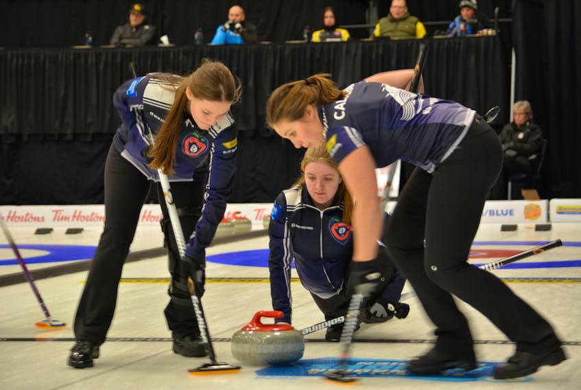 Cate Fitzgerald watches as  Lindsey Burgess, left,   Kate Callaghan sweep during action at the New Holland Canadian junior curling championships in Langley, B.C., on Saturday. Contributed