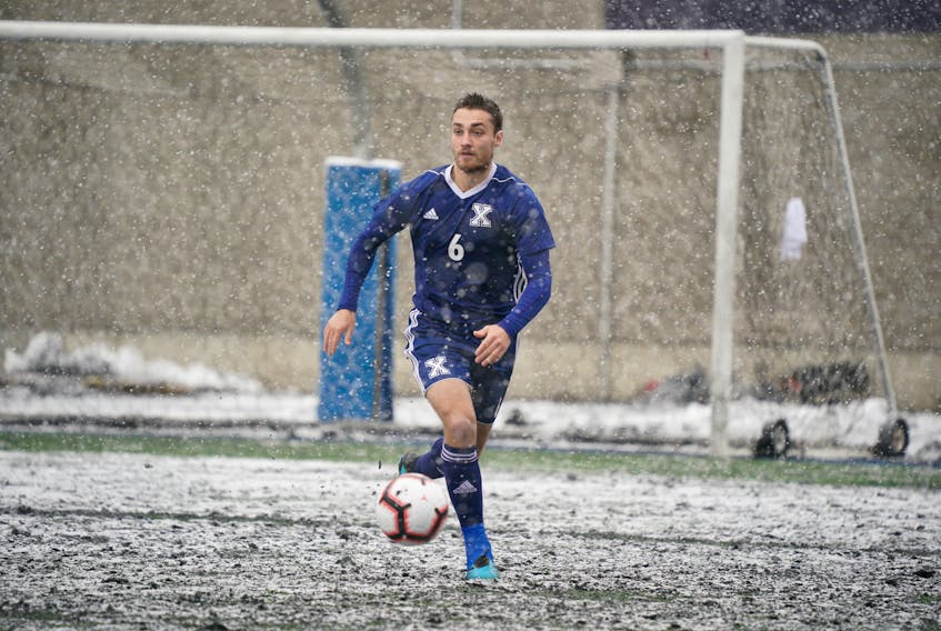 St. Francis Xavier X-Men defender Sam Charron looks to move the ball upfield against the Carleton Ravens on a snowy day at the U Sports men's soccer championship in Montreal on Thursday.   James Hajjar / U SPORTS