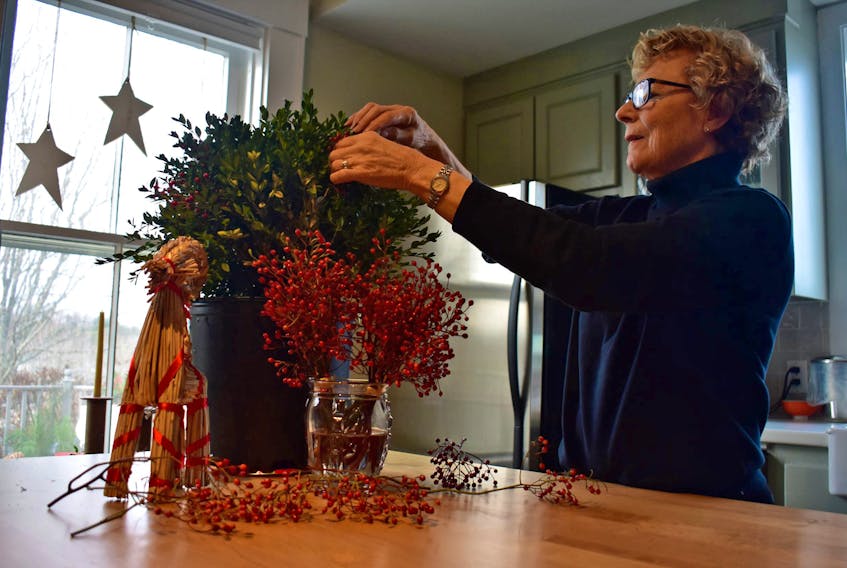 Gail Saker, a long-time volunteer and decorator for the Father Christmas Festival, works at preparing Barb Haley’s historic house for the Homes for the Holidays Tour. Haley’s decor is inspired by nature.