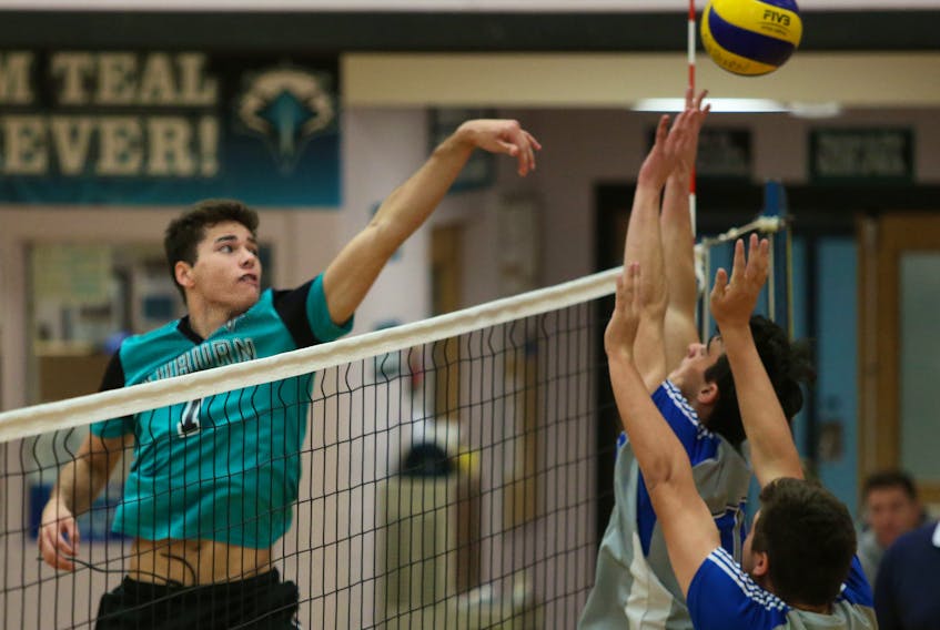 Auburn Drive Eagles’ Josh DeYoung hits past a pair of Lockview Dragon blockers in Capital Region high school boys’ volleyball quarter-final action on Tuesday.