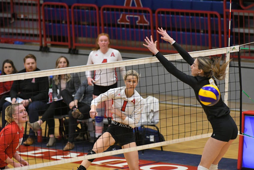 Acadia Axewomen’s Peyton DeWolfe (1) spikes past the block of Dalhousie Tigers’ Victoria  Turcot during AUS women’s volleyball action on Sunday in Wolfville. The Axewomen handed Dalhousie its first loss of the season. Peter Oleskevich
