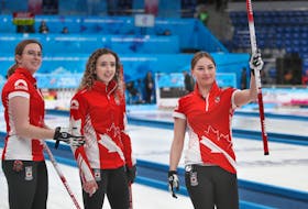 Truro’s Karlee Burgess, right, raises her broom to skip Mackenzie Zacharias, not pictured,  after Canada defeated Russia 9-8 to advance to the championship game at the world junior curling championships in Krasnoyarsk, Russia, on Friday. From left are lead Lauren Lenentine and second  Emily Zacharias.  RICHARD GRAY