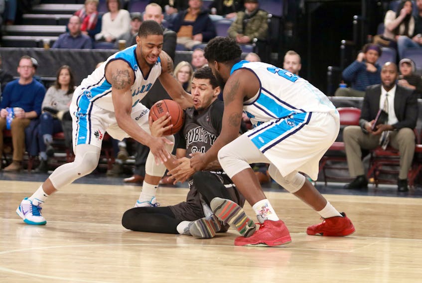 Moncton Magic’s Ronald Delph gets double-teamed by the Halifax Hurricanes’ Chris Johnson, left, and CJ Washington as he recovers the loose ball late in the second quarter of their NBL Canada game Friday evening.  ERIC WYNNE / The Chronicle Herald