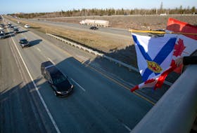 May 11, 2020--Watchers with flags of Nova Scotia and Canada watch as the hearse carrying the body of Sub-Lt. Abbigail Cowbrough approaches the Aerotech overpass along Hwy. 102 Monday evening.