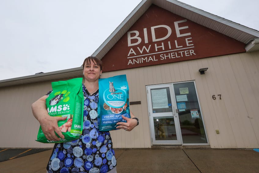 July 14, 2020—Jennifer Mills, animal care manager at BideAwhile animal shelter shows off some of the food donations. The Dartmouth shelter has been operating a pet food pantry to people with cats or dogs who need help to feed their pets. The shelter is asking for donations of unopened cat and dog food for the program.
ERIC WYNNE/Chronicle Herald