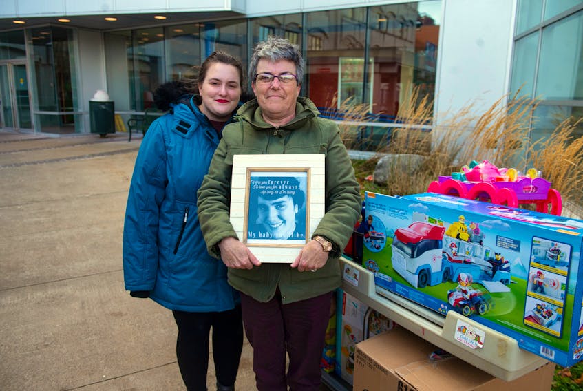 Carol Hayne holds a photo of her son Jason Marryatt after she and her daughter Laura Marryatt brought down a busload of toys from Richmond County to the IWK Health Centre on Wednesday, Nov. 13, 2019.